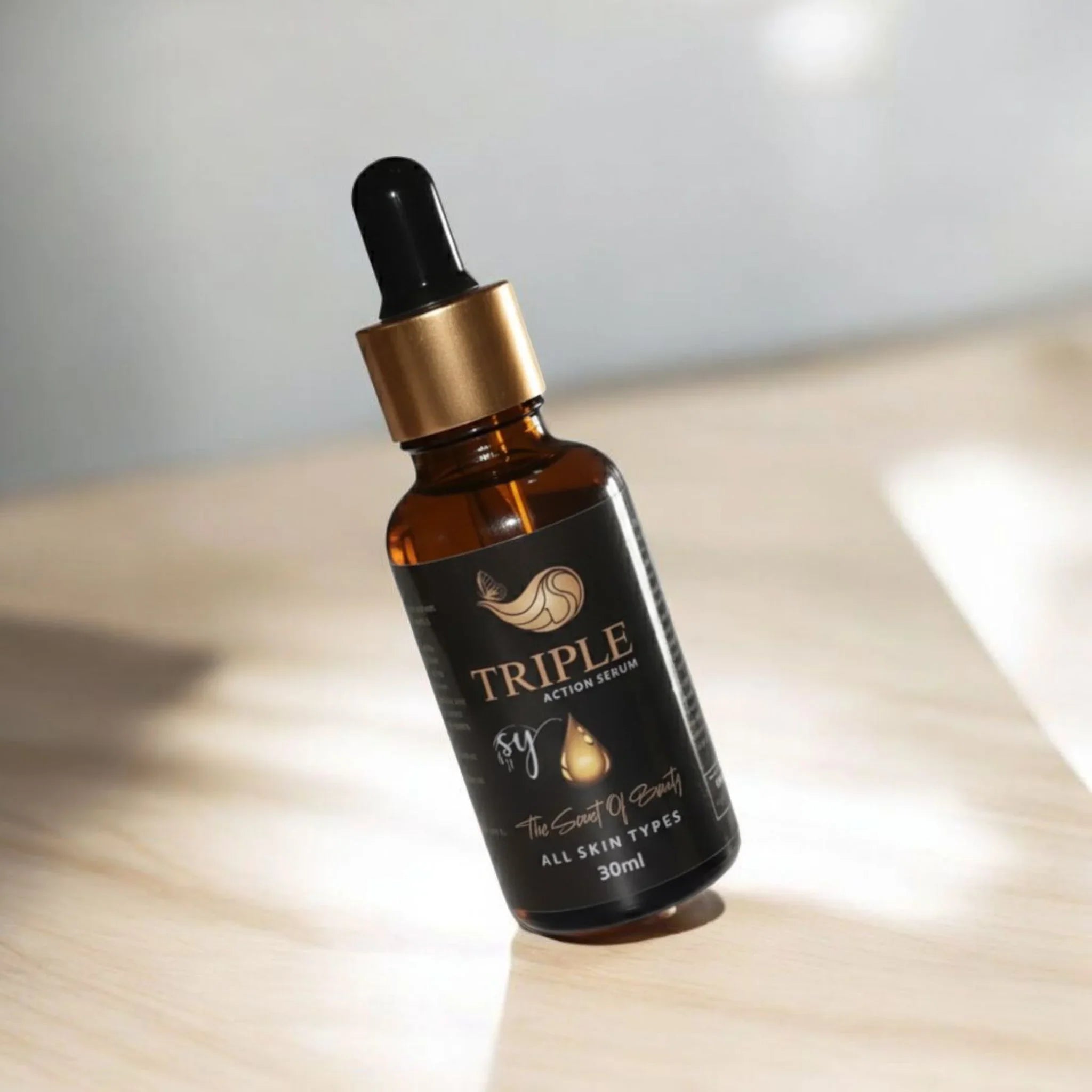 Triple Action Serum bottle for all skin types with dropper on light wooden surface