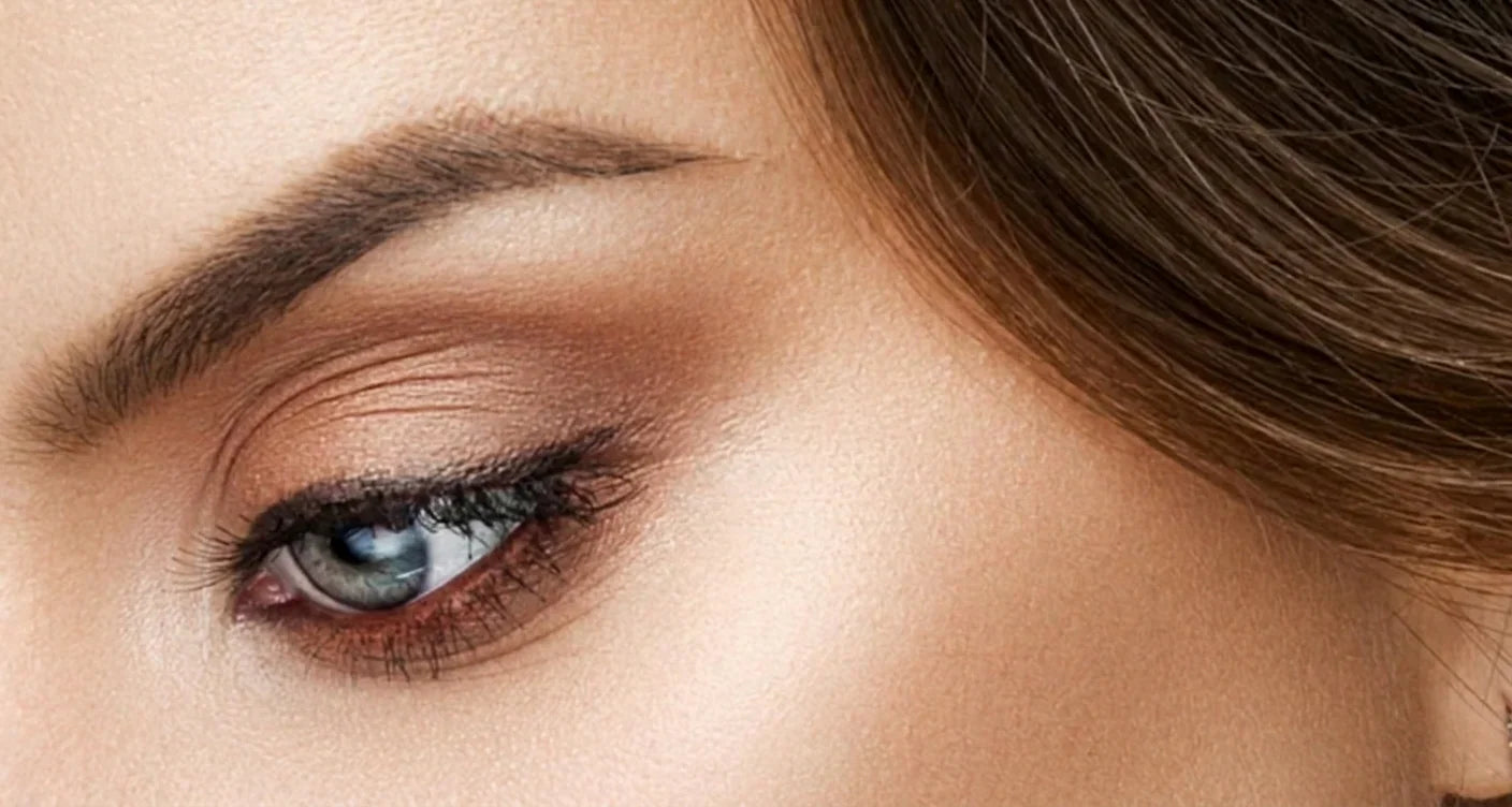 Close-up of a woman's eye with natural makeup and defined eyebrow